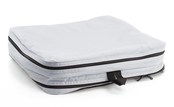 An empty and zipped closed Northwest Sky (light grey) Aether Large Laundry Aeronaut 45 Packing Cube all-fabric side up.